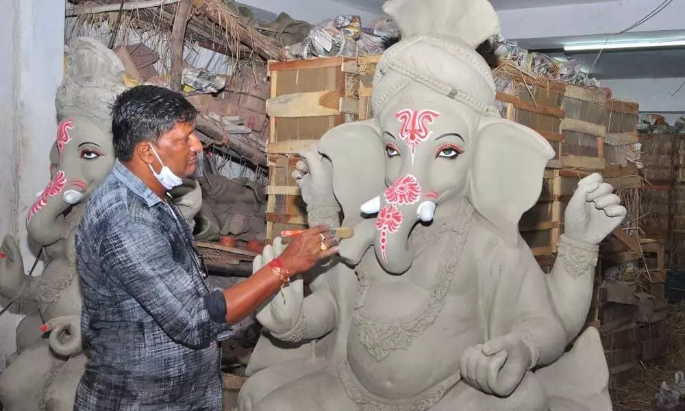 The couple D Narasimha Rao and Pushpa decorating eco-friendly Ganesh idols for selling in Khammam