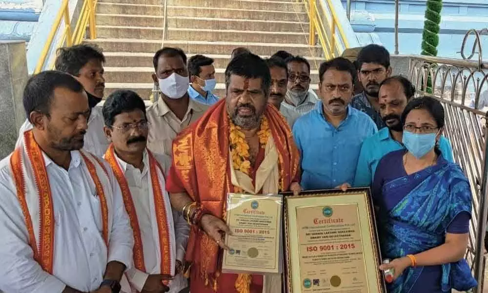 Tourism Minister M Srinivasa Rao and Simhachalam Devasthanam Executive Officer M V Surya Kala displaying the ISO Certification at the temple in Visakhapatnam on Saturday