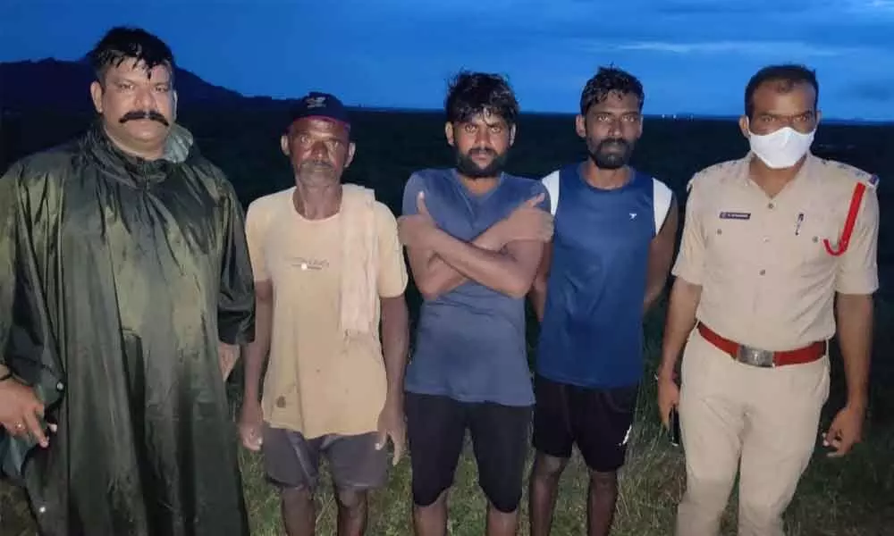 Police seen with three of the rescued fishermen at Madduvalasa reservoir on Friday