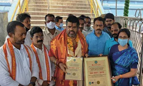 Tourism Minister M Srinivasa Rao and Simhachalam Devasthanam Executive Officer M V Surya Kala displaying the ISO Certification at the temple in Visakhapatnam on Saturday