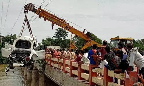 Police retrieving the car from the canal at Adarshnagar Centre near Suryalanka in Guntur district on Sunday