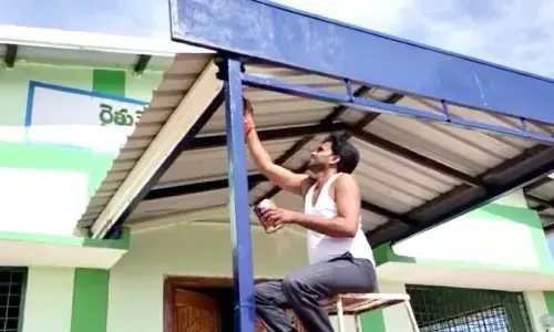 Sarpanch Mallesh painting the Rythu Vedika of Pedda Padishala village