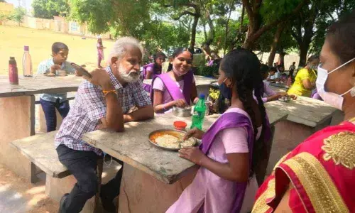 District Education Officer M Sairam interacting with the students of ZHP School at Military Colony in Kurnool on Wednesday.