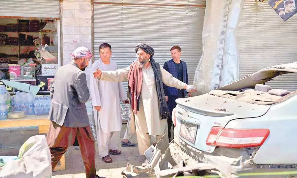Taliban fighters and residents gather at the site of an explosion in Kabul, Afghanistan on Saturday.  A sticky bomb exploded in the capital Kabul wounding a few people, said police officials