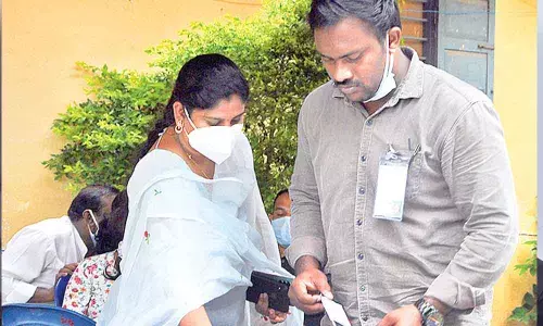 Elections staff collecting cell phones of agents and duty staff at counting centre at Montessori Women College in Vijayawada