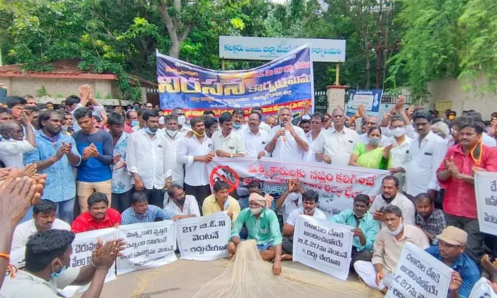 Fishermen staging a protest in front of the Collectorate in Kakinada on Monday