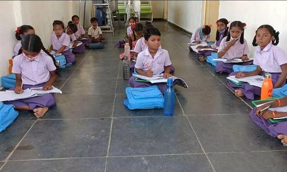 Due to lack of classrooms, students are seated on the floor at a government school in Burandoddi village in C Belagal mandal in Kurnool district