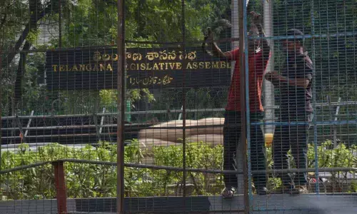 Workers fix barricades in front of the State Legislature Assembly building on the eve of monsoon session, in Hyderabad