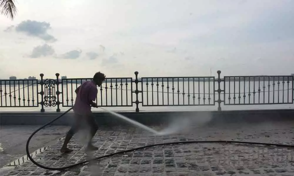 A worker cleaning the footpath on Tank Bund ahead of Sunday-Funday event Photo: Ch Prabhu Das