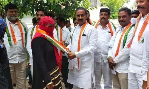 TPCC State secretary Patel Ramesh Reddy inviting a Muslim woman into the party at a programme in Kandagatla village on Sunday