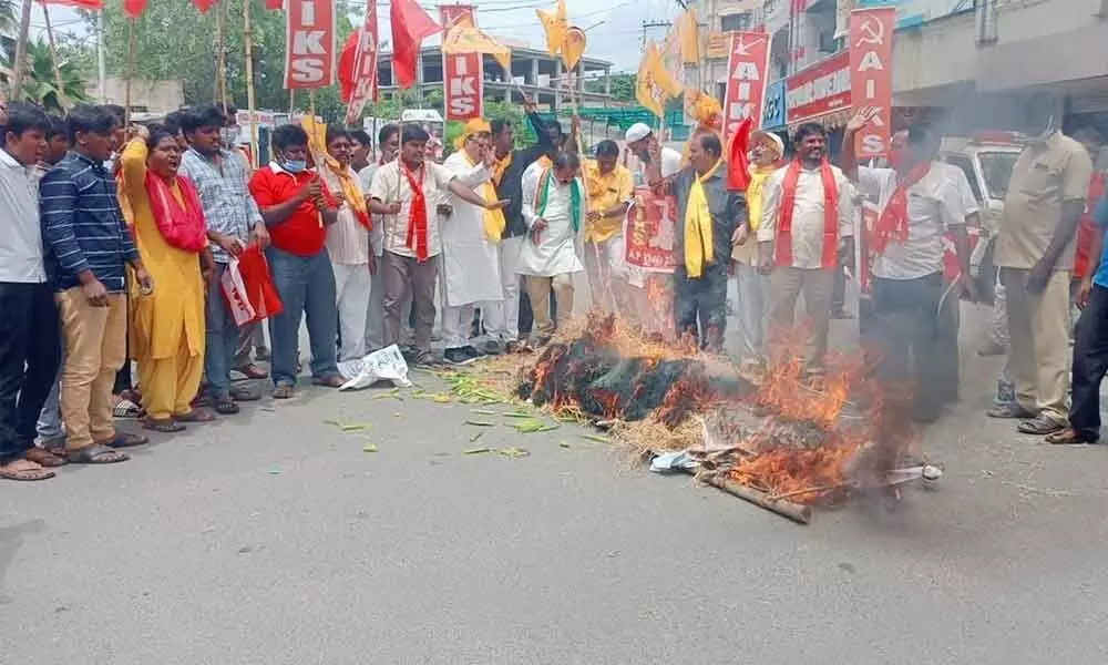 Protesters burning the effigies of Prime Minister Narendra Modi, Ambani and Adani at Koti Reddy circle in Kadapa on Monday