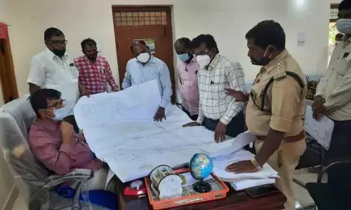 Officials examining the map of forest lands in Chandampeta mandal, at Tahsildar office in Chandampet on Wednesday