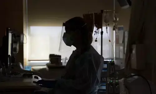 FILE - In this Nov. 19, 2020, file photo, a nurse works on a computer while assisting a COVID-19 patient at a hospital in Los Angeles. (Photo | AP)