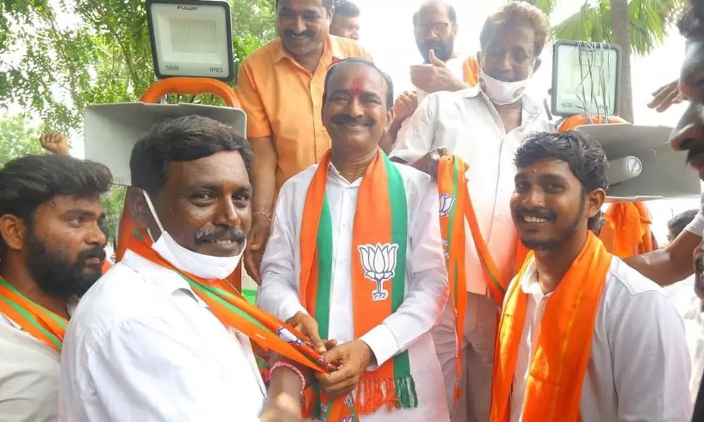 BJP leader E Rajender inviting a TRS leader into the party at Jammikunta in Karimnagar district on Friday