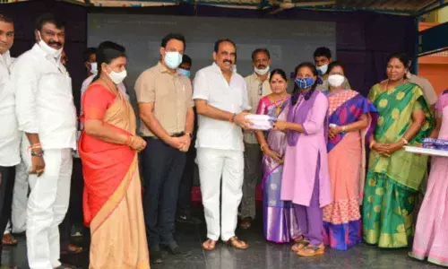 Minister Balineni Srinivasa Reddy distributing sanitary napkins to girl students at GGH School in Ongole on Tuesday