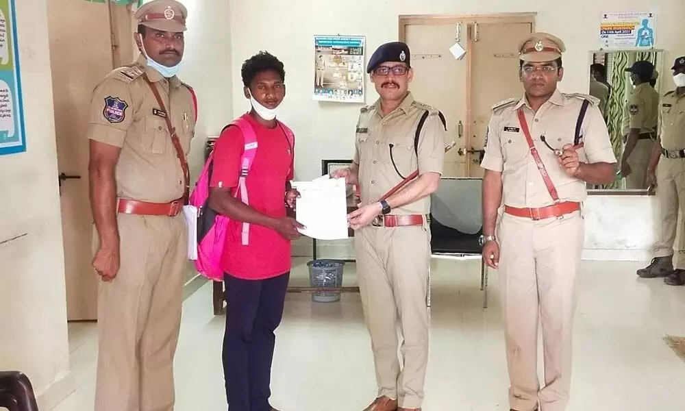 SP Sunil Dutt giving a cheque for Rs 20,000 to tribal student K Joga Rao, who is the All India 9th ranker in sports, at Dummagudem police station on Friday