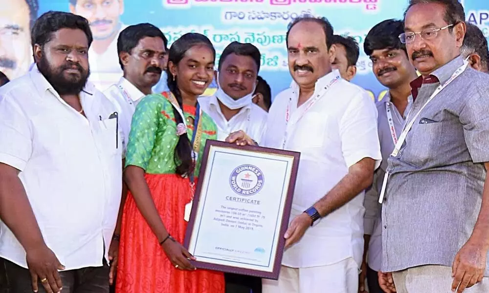 Minister Balineni Srinivasa Reddy  presenting certificate from Guinness Book of World Records and gold medal to Adipudi Devisri in Ongole on Friday