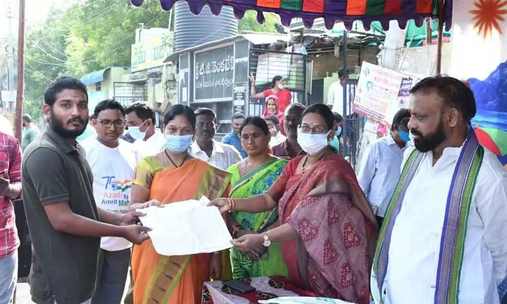 Mayor B Y Ramaiah and Municipal Commissioner D K Balaji distributing cloth bags to vegetable buyers at C Camp Rythu Bazaar in Kurnool on Monday.
