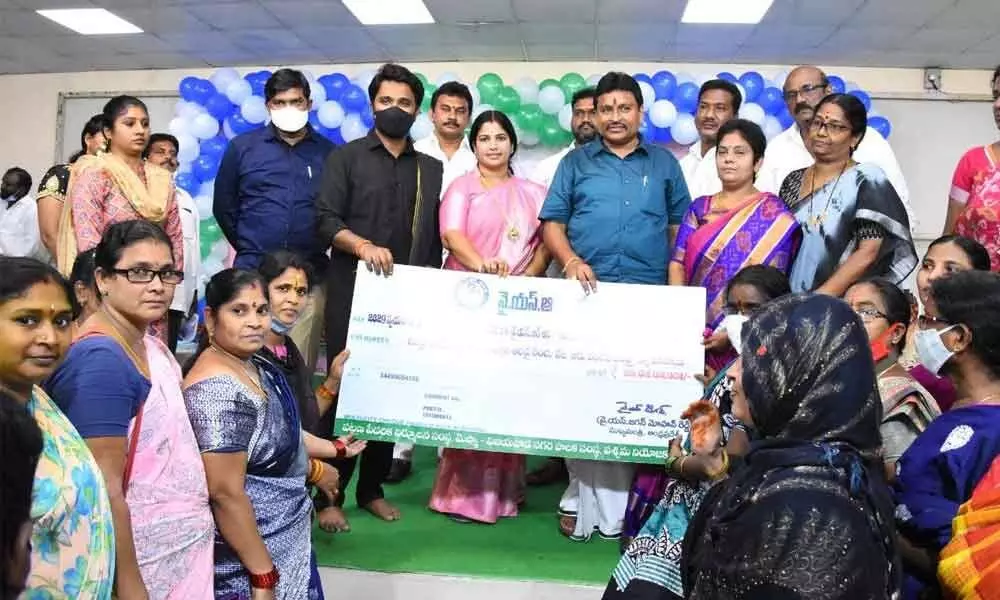 Endowments Minister Velampalli Srinivas handover cheque to Self Help Group members in West Assembly constituency limits, Vijayawada on Monday