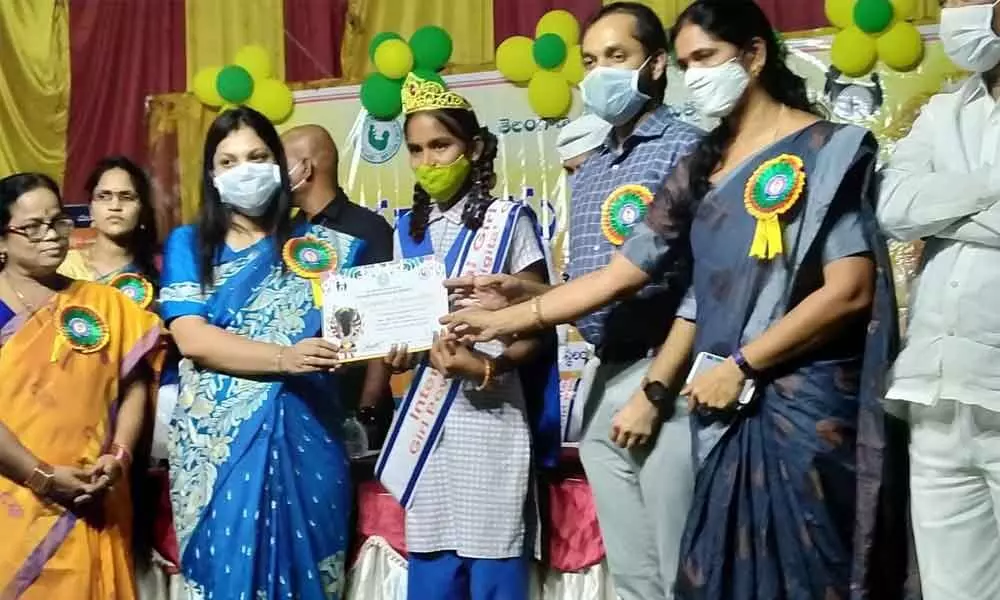 Collector Pamela Satpathy presenting a meritorious certificate to a girl during international girl child day celebrations held at Bhongir on Monday