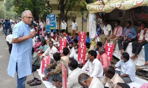 CPM state secretariat member Sarma addressing forest workers at the relay hunger strike on Hare Krishna Road in Tirupati on Monday.