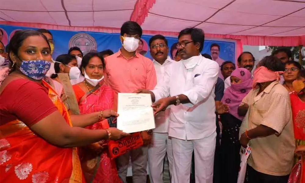 Minister for Transport Puvvada Ajay Kumar handing over the allotment letters of double bedroom houses to beneficiaries in Khammam