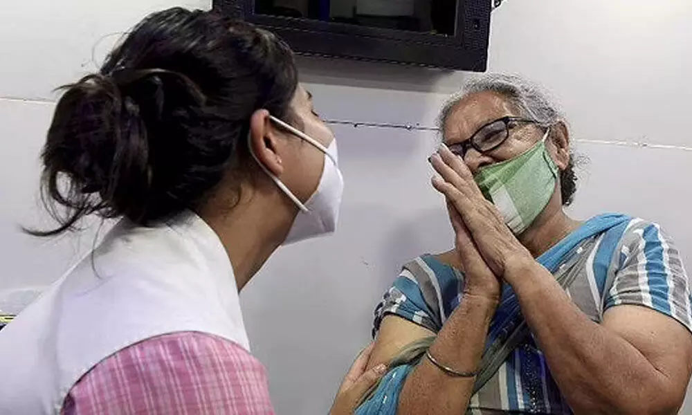 A beneficiary folding hands in gratitude to a health worker before receiving a dose of Covid vaccine in New Delhi. (File photo| PTI)