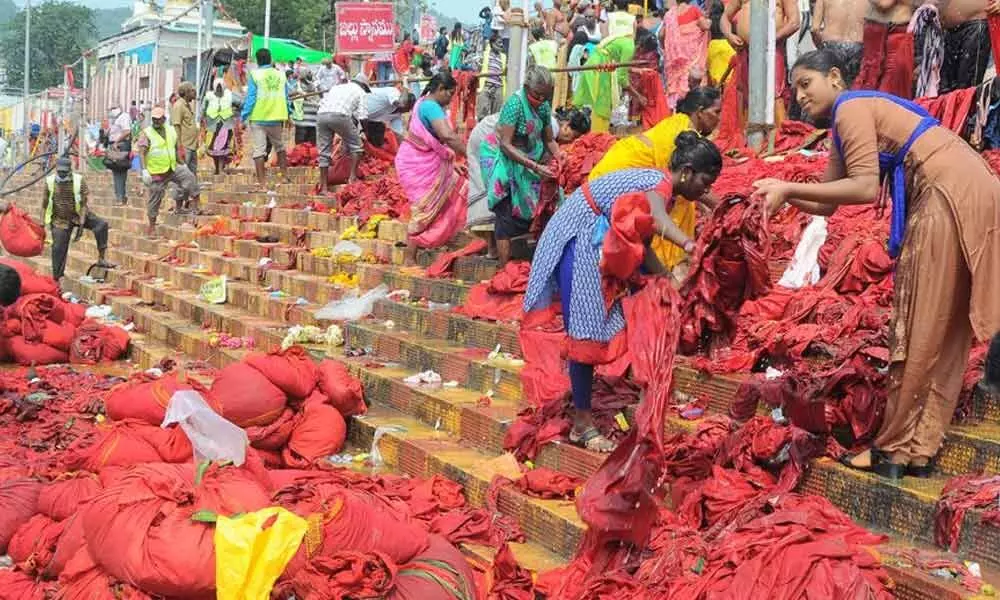 Sanitary workers cleaning the red robes used by Bhavani devotees at Krishnaveni ghat on the banks of River Krishna in Vijayawada on Monday	Photo: Ch Venkata Mastan