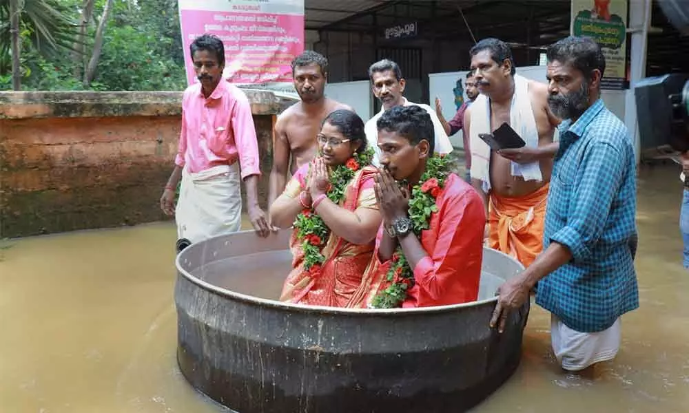 Kerala couple reaches flooded hall in cooking vessel, get married