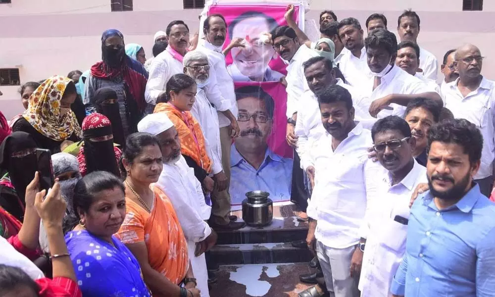 The double bedroom houses beneficiaries performing “Palabhishekam” to the portrait of Minister Ajay in Khammam on Monday