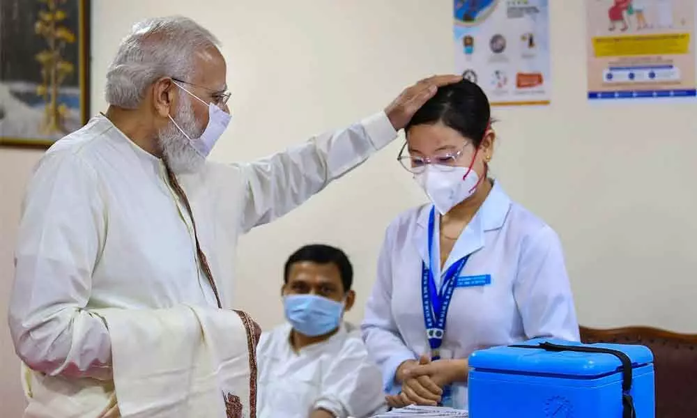 Prime Minister Narendra Modi appreciates a medic at the vaccination centre of Ram Manohar Lohia Hospital, in New Delhi on Thursday