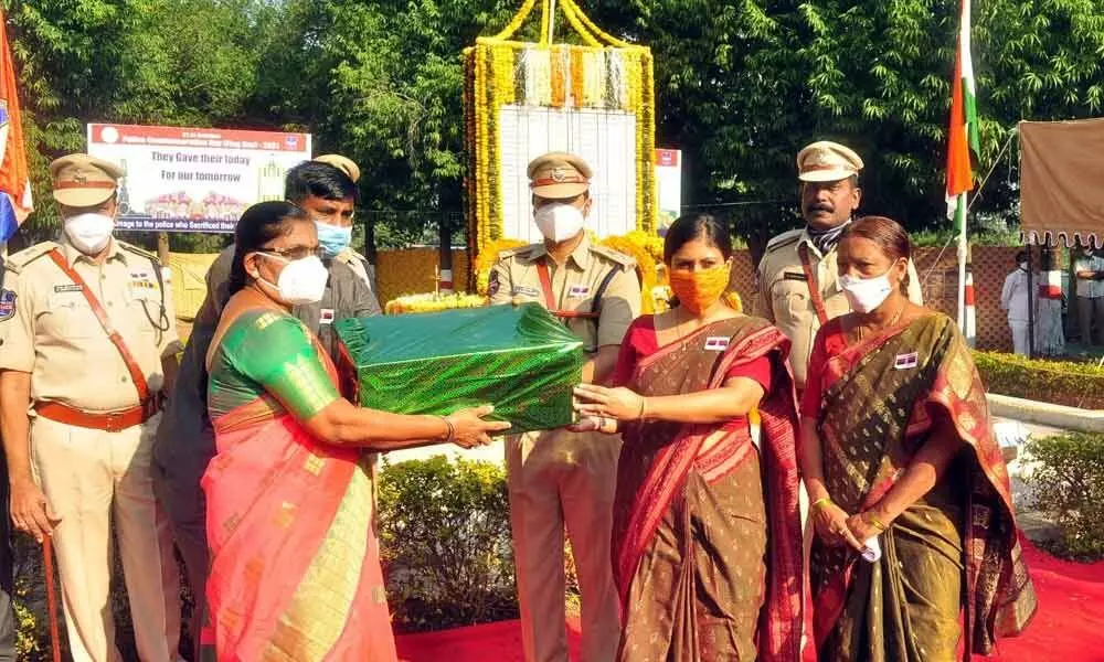 District Collector Sikta Patnaik presenting gifts to the family members of martyred policemen in Adilabad on Thursday