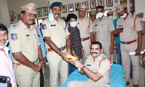 Kothagudem DSP Venkateswara Babu distributing fruits to the staff who donated blood at a camp in Kothagudem on Saturday