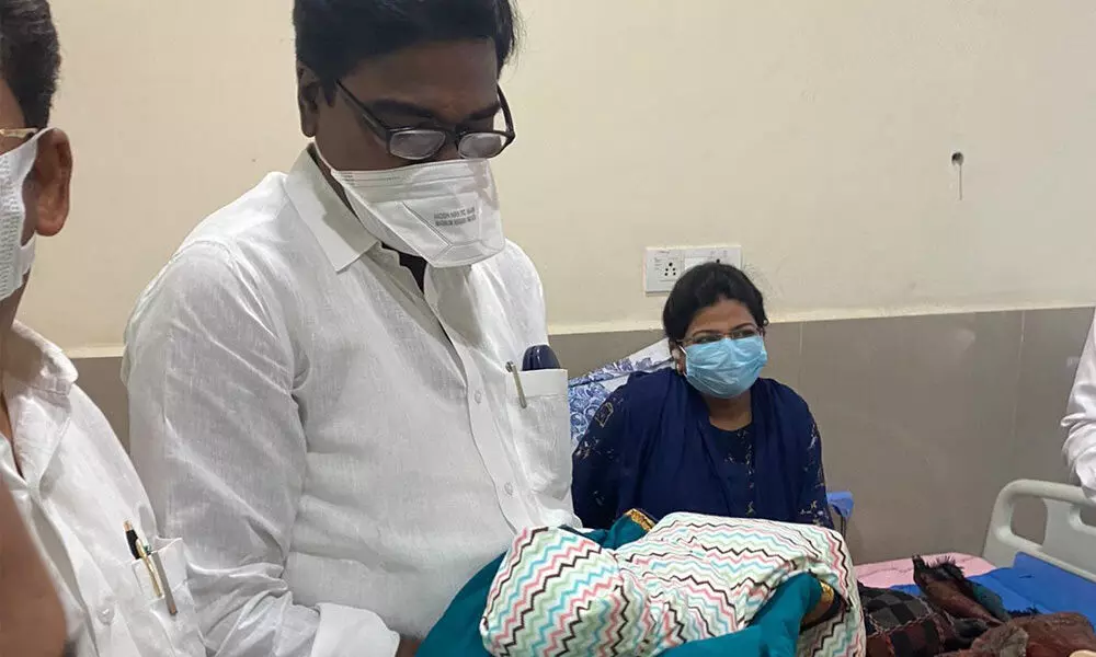 Minister for Transport Puvvada Ajay Kumar carrying the newborn baby girl of Additional Collector Snehalatha Mogili at the Khammam government hospital on Sunday