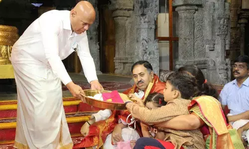 TTD Additional EO A V Dharma Reddy offering Srivari Prasadam to Trust Board member Krishnamurthy Vaidyanathan at Tirumala on Sunday