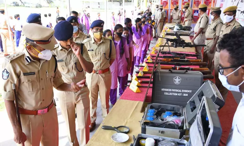 DIG P Venkatarami Reddy, SP Ch Sudheer Kumar Reddy and students having a look at the weapons kept on display at the Open House at Police Parade grounds in Kurnool on Tuesday