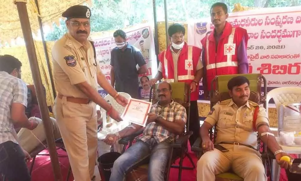 Nagarkunool DSP Mohan Reddy distributing certificates to the police personals participating in the mega blood donation camp at Nagarkurnool police headquarters on Tuesday