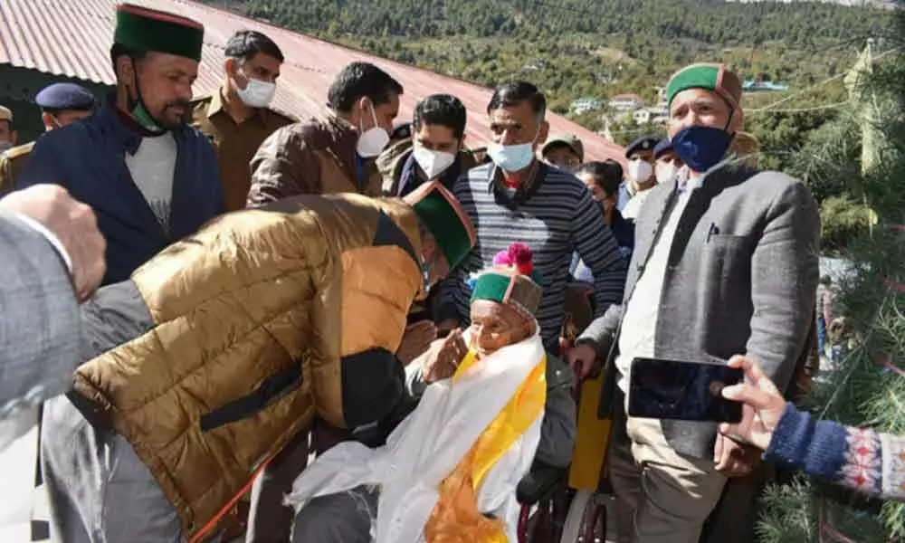 First voter of independent India 104- years- old Shyam Saran Negi greeted by officials as he reached the polling booth to cast vote during the Mandi parliamentary by-elections, at Kalpa in Kinnaur on Saturday