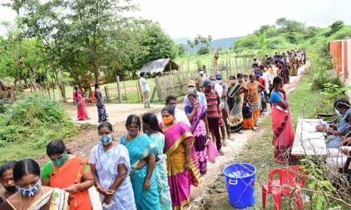 Women voters stand in a queue to cast their votes in Betyapalle village in Gopavaram mandal under Badvel Assembly constituency in Kadapa district on Saturday