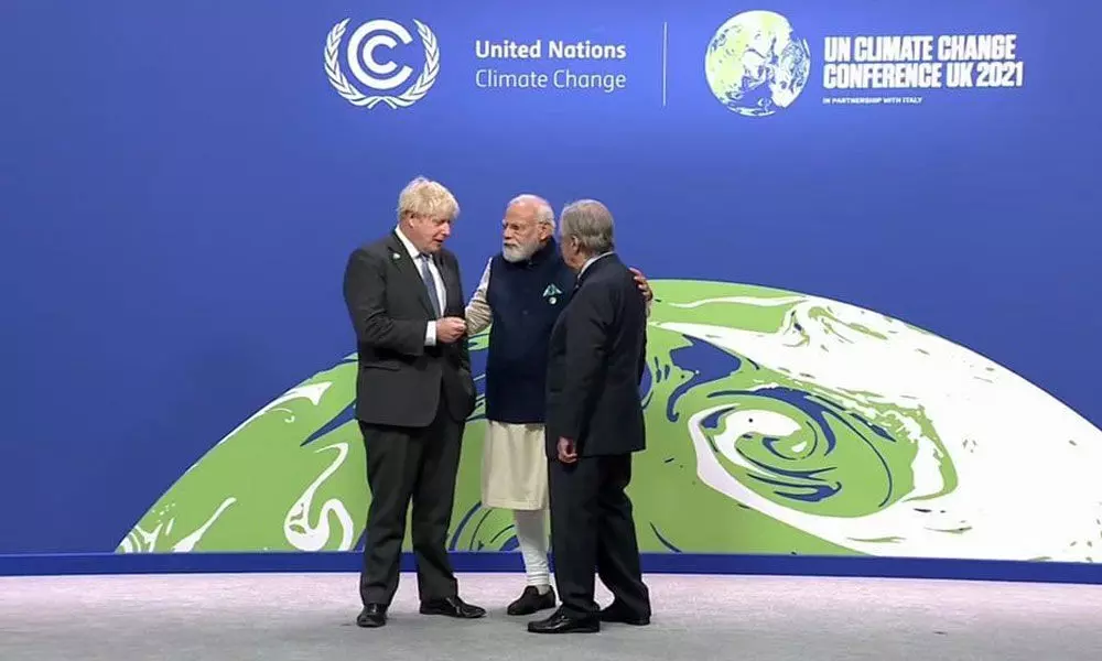 British Prime Minister Boris Johnson, left, and UN Secretary-General Antonio Guterres, right, greet India Prime Minister Narendra Modi at the COP26 UN Climate Summit in Glasgow on Monday