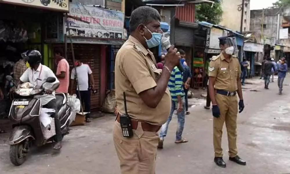 File photo of Chennai Police advising shopkeepers to keep social distancing at Pudupet. (Photo | R Satish Babu, EPS)