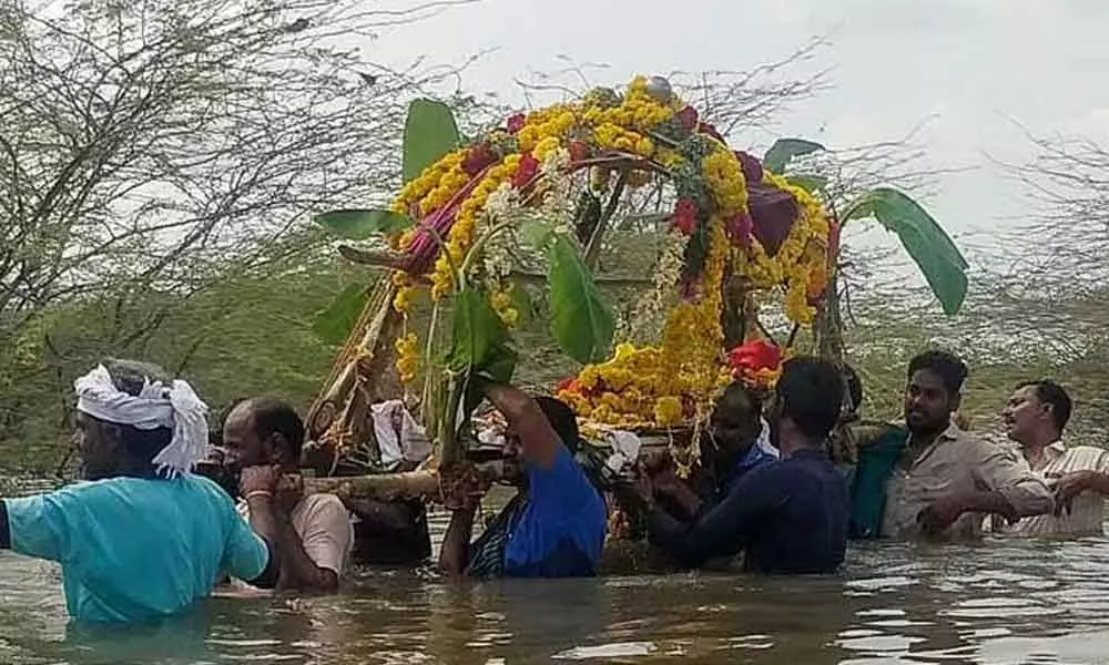 Villagers carry a body across the lake at Eluvichampatti in Pudukkottai district
