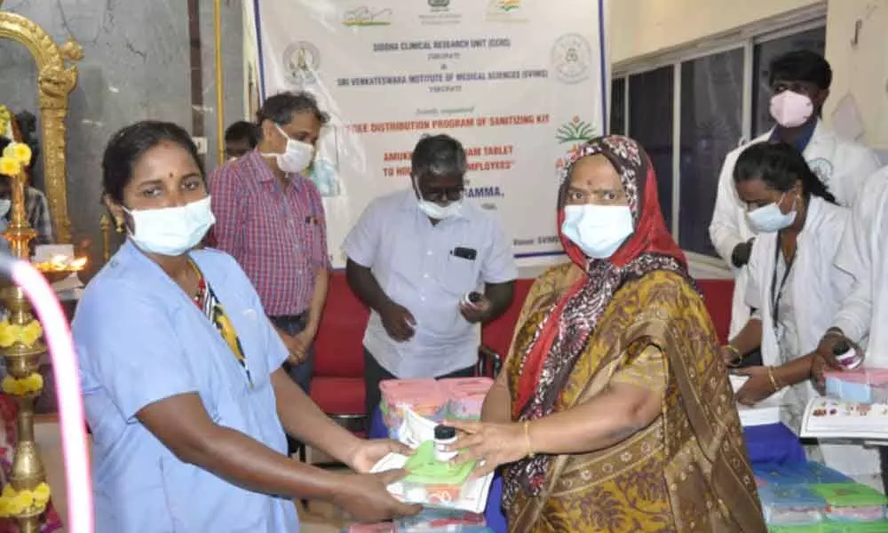 SVIMS Director Dr B Vengamma distributing sanitiser kits and Amukkara Choornam tablets to sanitary staff on Tuesday. In-charge of Siddha Clinical Research Unit Dr K Samraj and others are also seen.