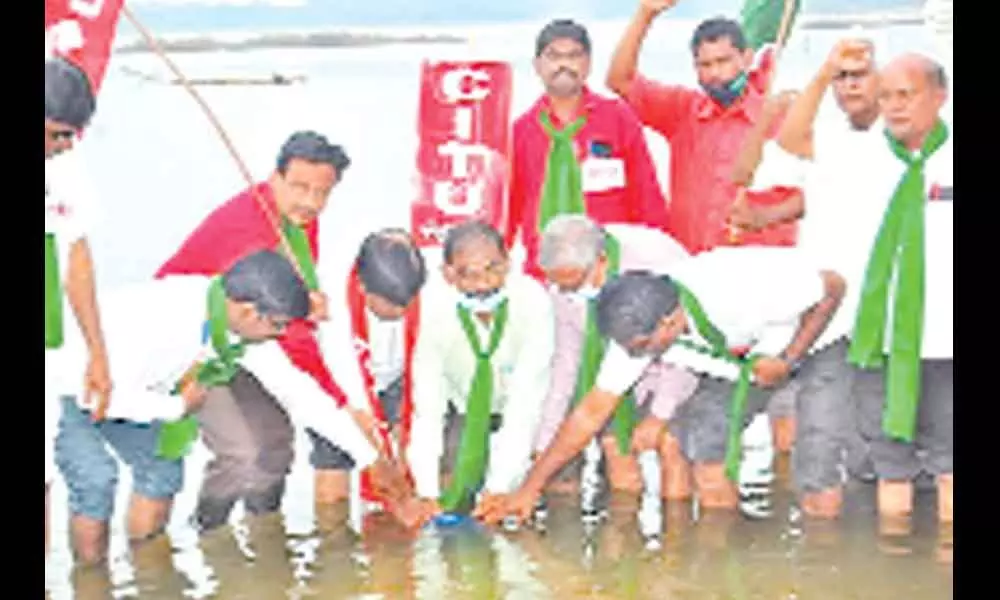AIAWU General Secretary B Venkat along with CPM leaders during ashes immersion ceremony in river Godvari at Bhadrachalam