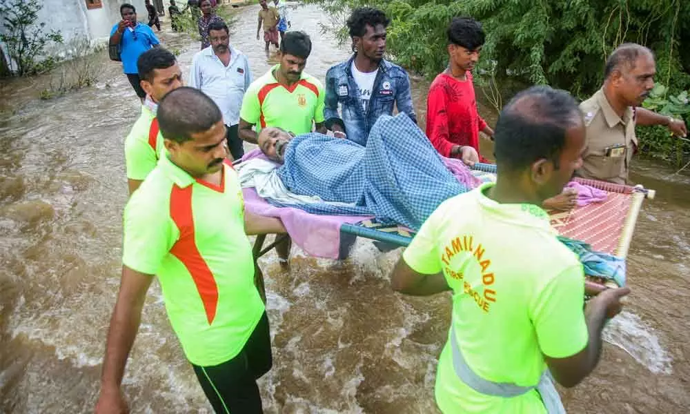 Firefighters evacuate people from a flooded area after heavy rain in Kanyakumari