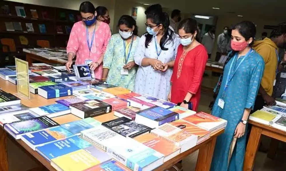 Students browsing through books at the exhibition organised as a part of the National Library Week celebrations at GITAM on Monday