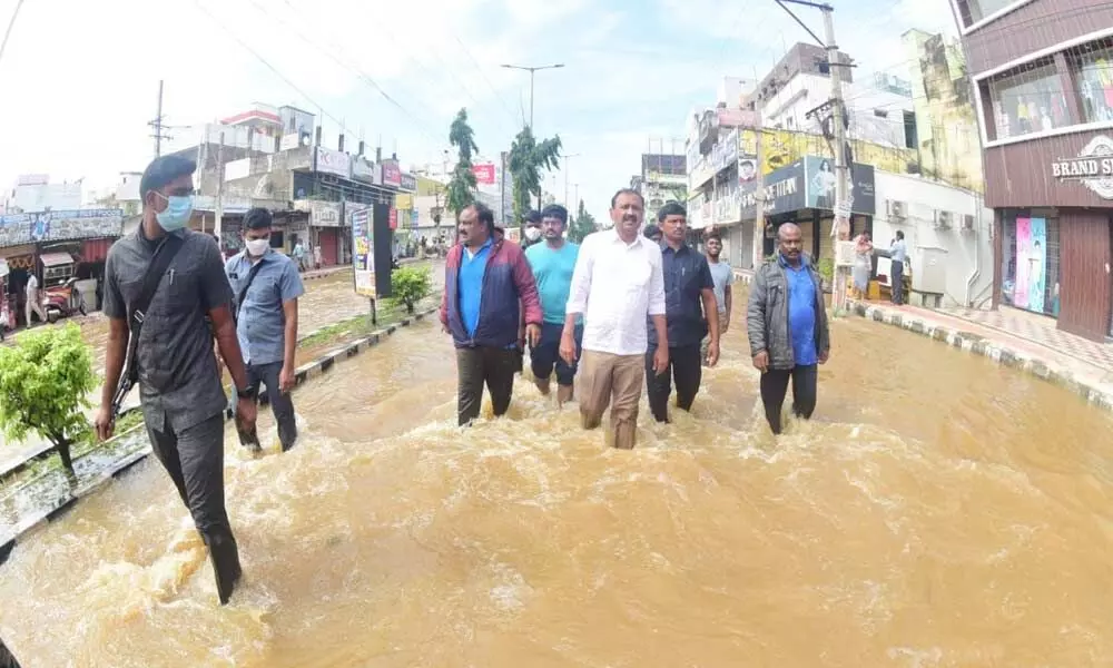 City MLA Bhumana Karunakar Reddy who inspected rain-hit areas in the city wading through knee-deep water in AIR bypass road