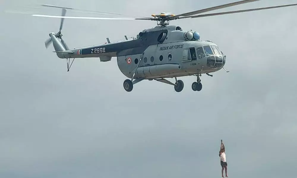 A stranded person is being rescued by helicopter from swirling waters of Chitravati river at Kadiri in Anantapur district on Friday