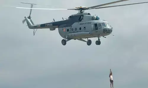 A stranded person is being rescued by helicopter from swirling waters of Chitravati river at Kadiri in Anantapur district on Friday