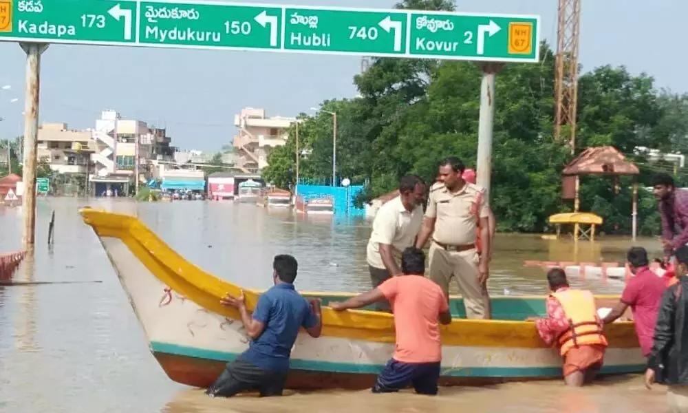 Police using boats for shifting local people in Kovur. (Right) Damaged railway track at Padugupadu.